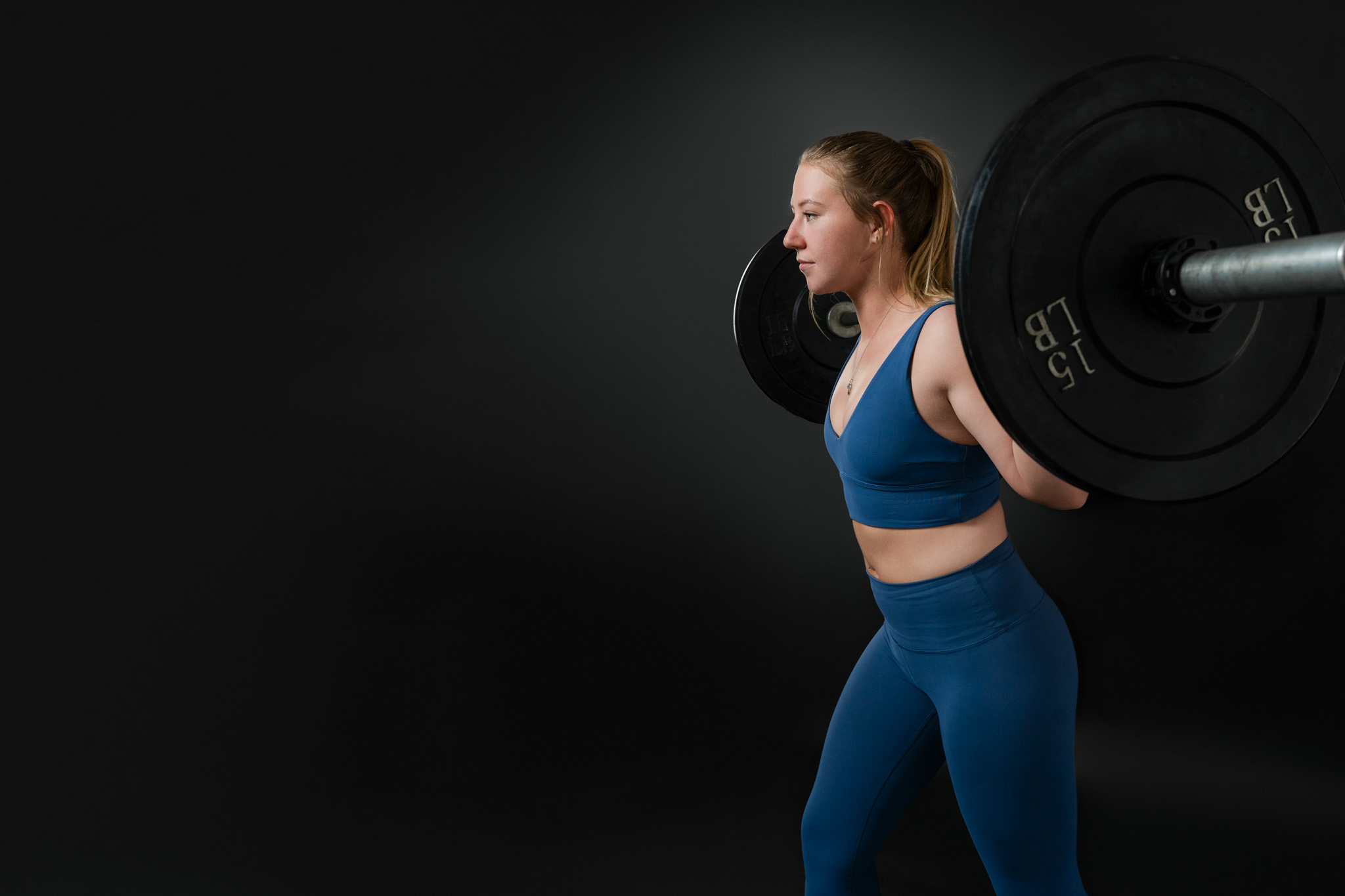 Fitness coach performing a barbell squat during a strength training branding session in Tucson, Arizona, featuring athletic personal branding photography for health and wellness professionals | Jessica Korff Studios Tucson, AZ