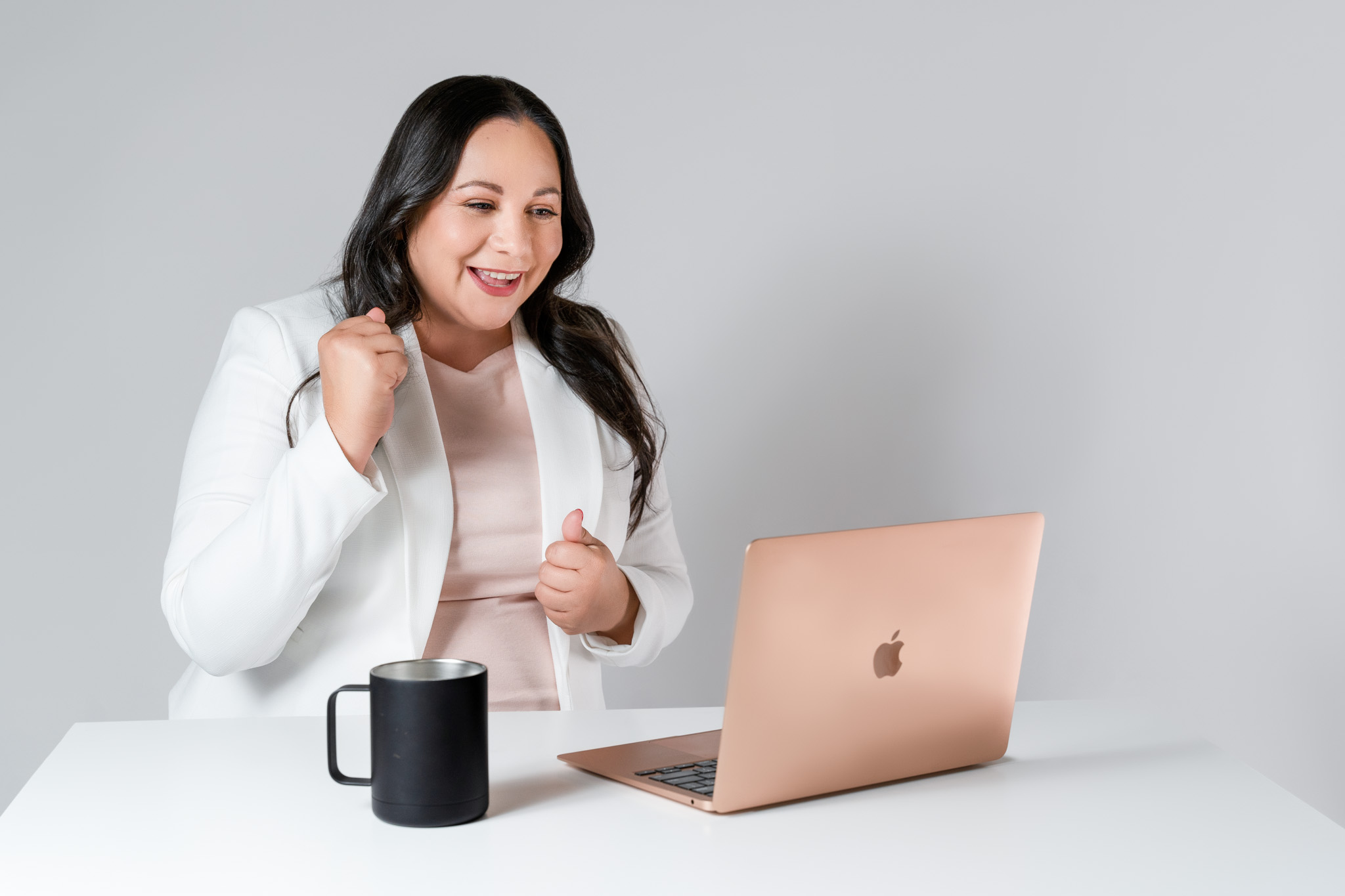 Female business owner celebrating while working on a laptop during a personal branding photography session in Tucson, Arizona, showcasing joyful entrepreneur lifestyle imagery |  | Jessica Korff Studios Tucson, AZ