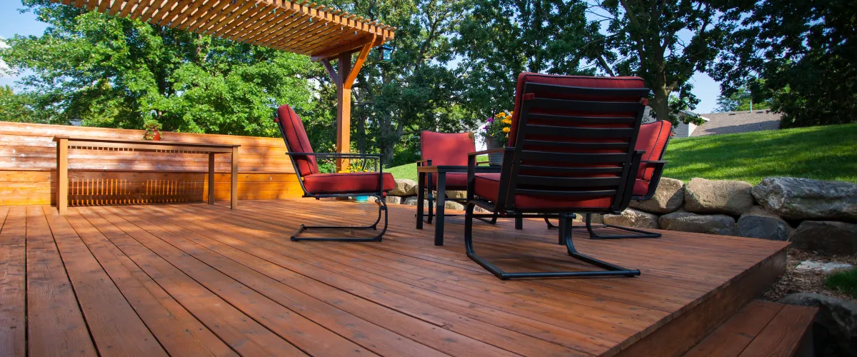 Backyard patio deck with a wooden pergola, modern outdoor seating, and scenic landscape views Backyard patio deck with a wooden pergola, modern outdoor seating, and scenic landscape views