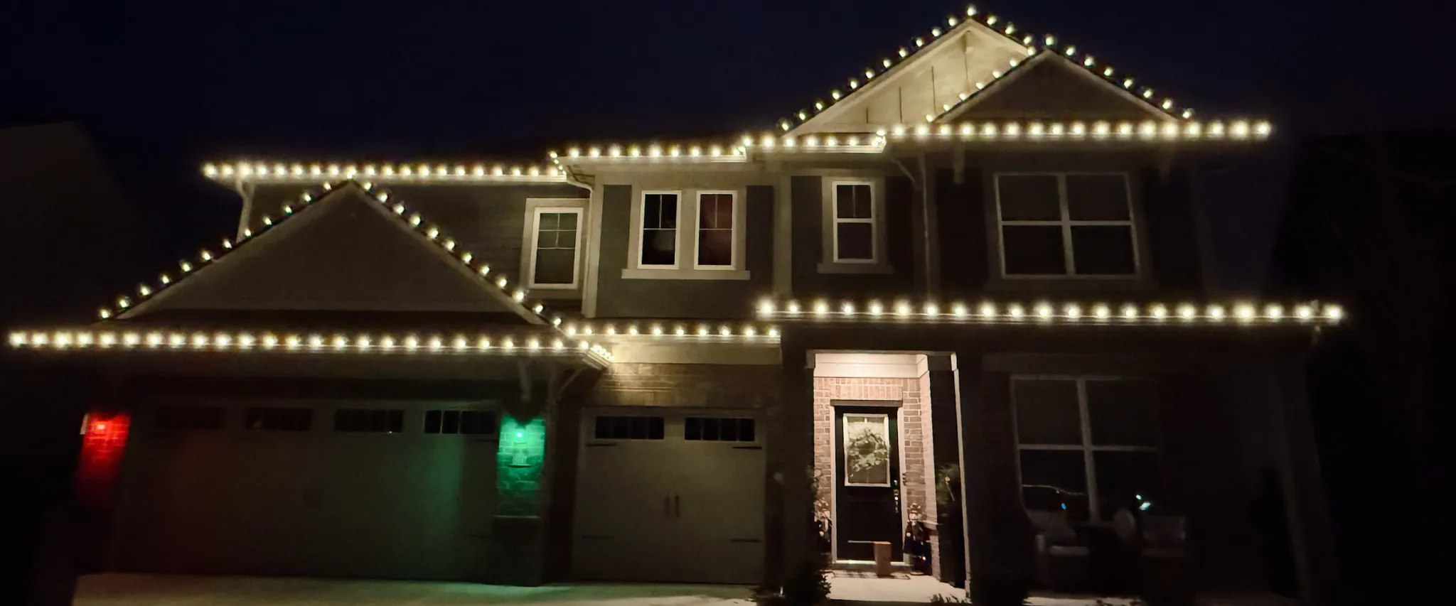 Two-story home with clean symmetrical permanent lighting for the holidays Two-story home with clean symmetrical permanent lighting for the holidays