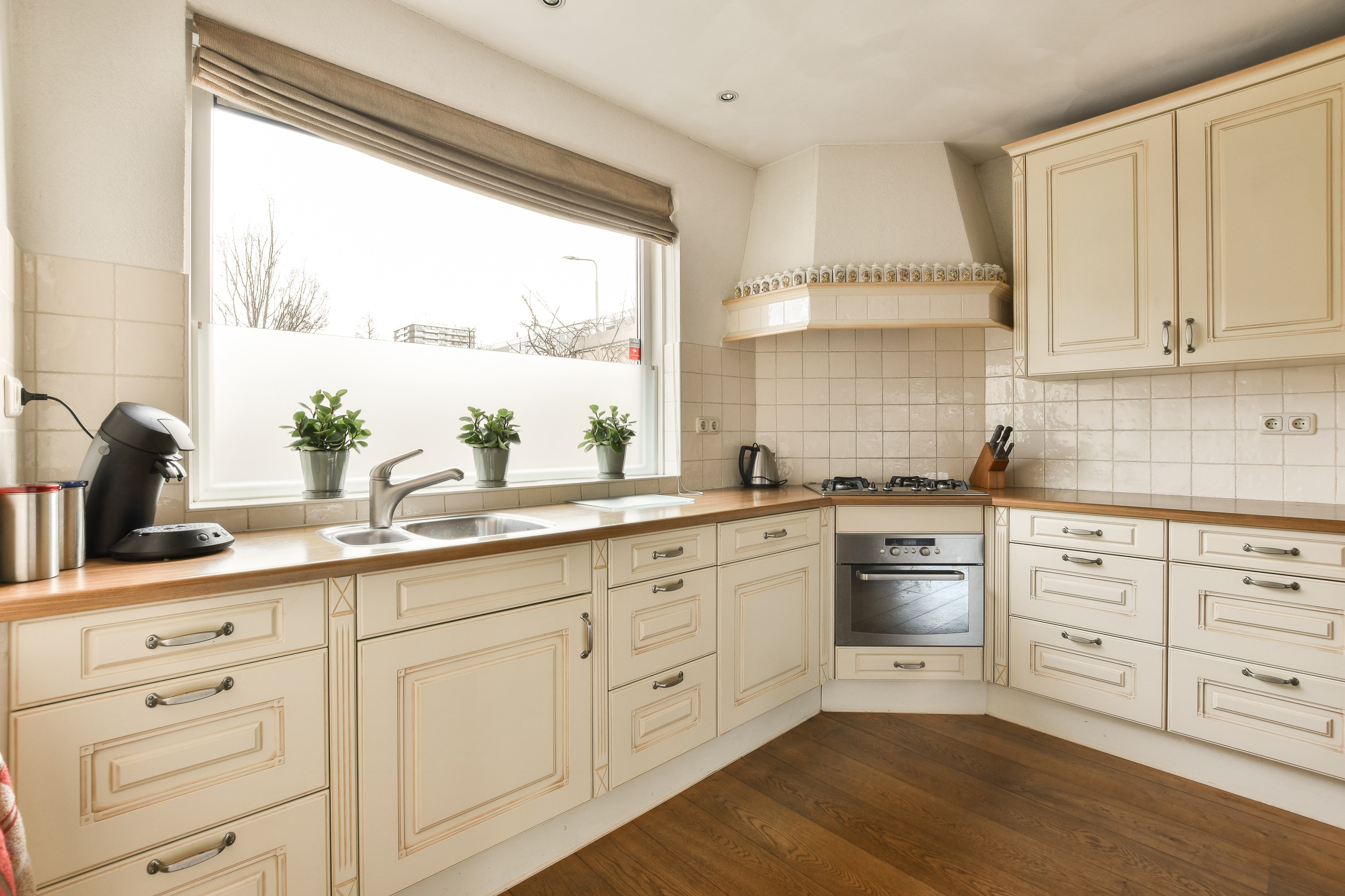 a kitchen with white cabinets and a window