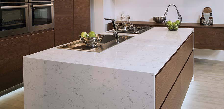 a kitchen counter with a sink and a bowl of fruit