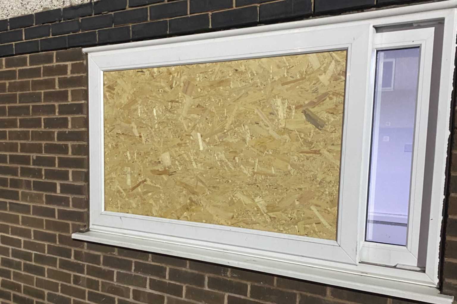 A smashed window boarded up in st helens