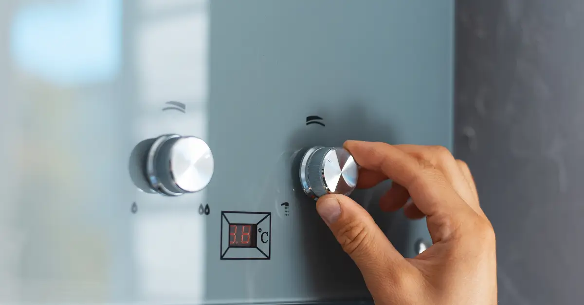 A modern tankless water heater is mounted on a blue wall, featuring three control knobs and a digital display showing a temperature of 53°C and system indicators. A modern tankless water heater is mounted on a blue wall, featuring three control knobs and a digital display showing a temperature of 53°C and system indicators.