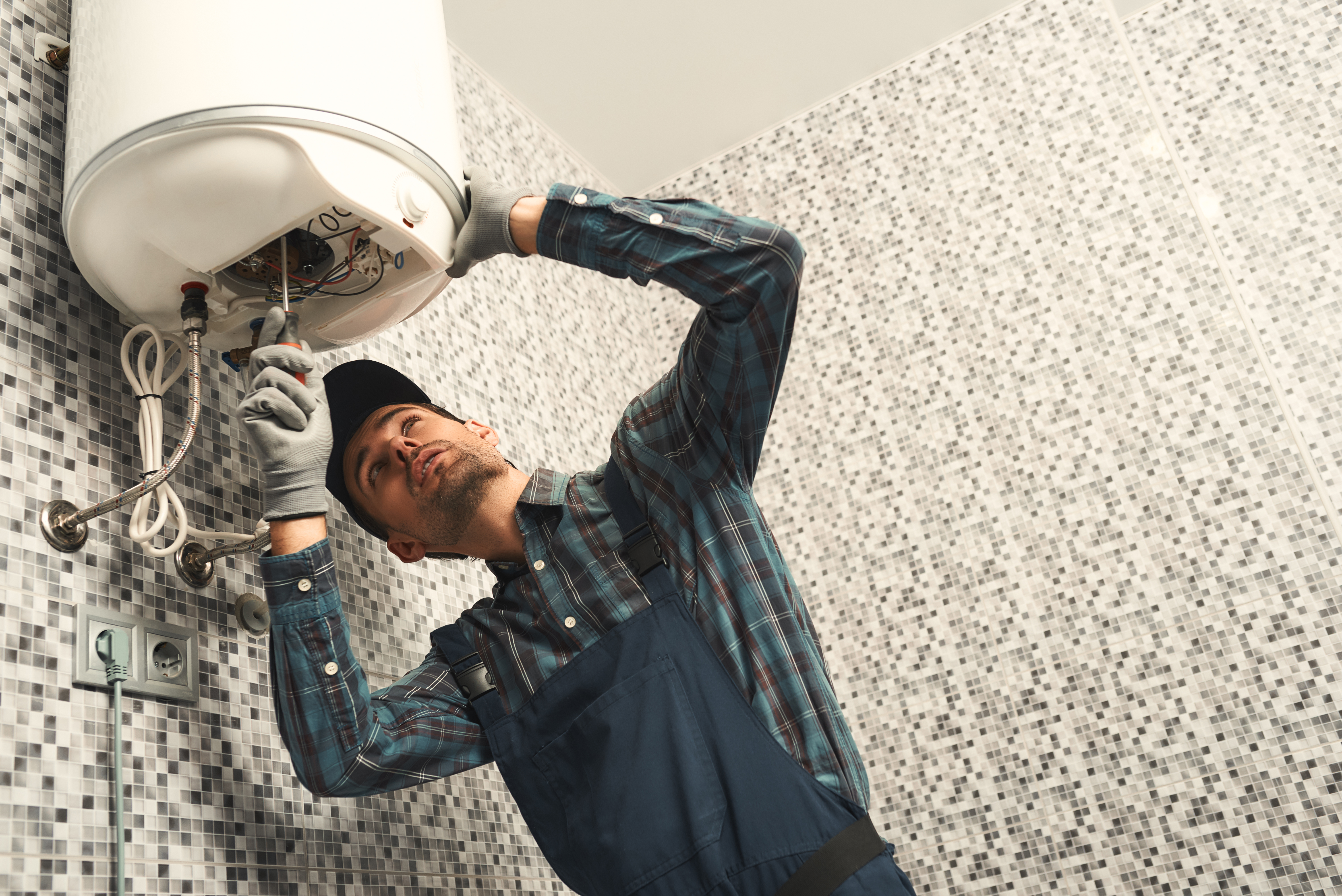 plumber installing a hot water heater plumber installing a hot water heater