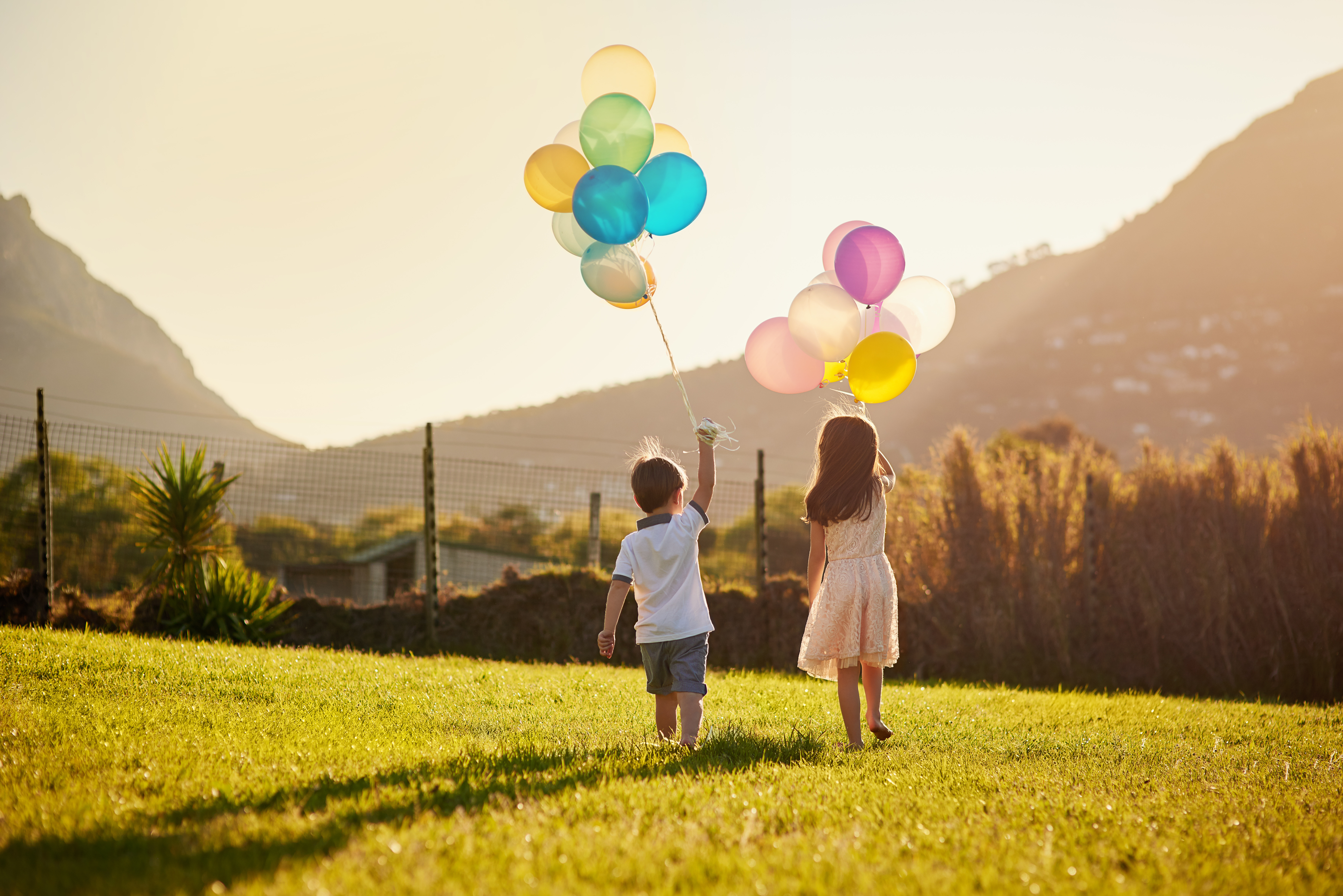 two children holding balloons two children holding balloons