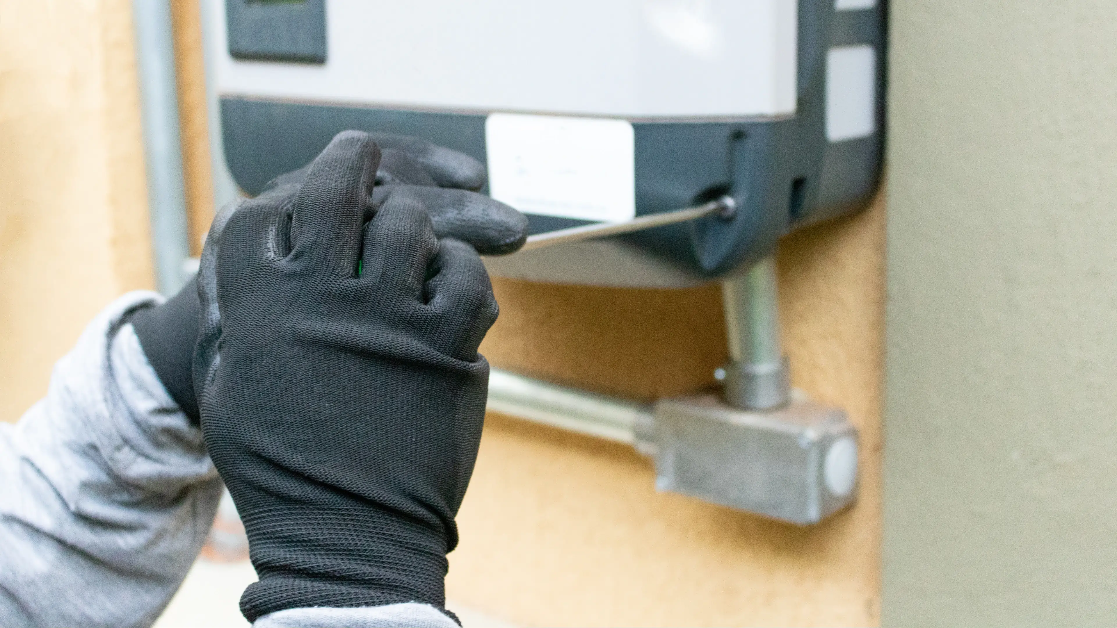 A solar technician is installing a solar battery on a wall. 