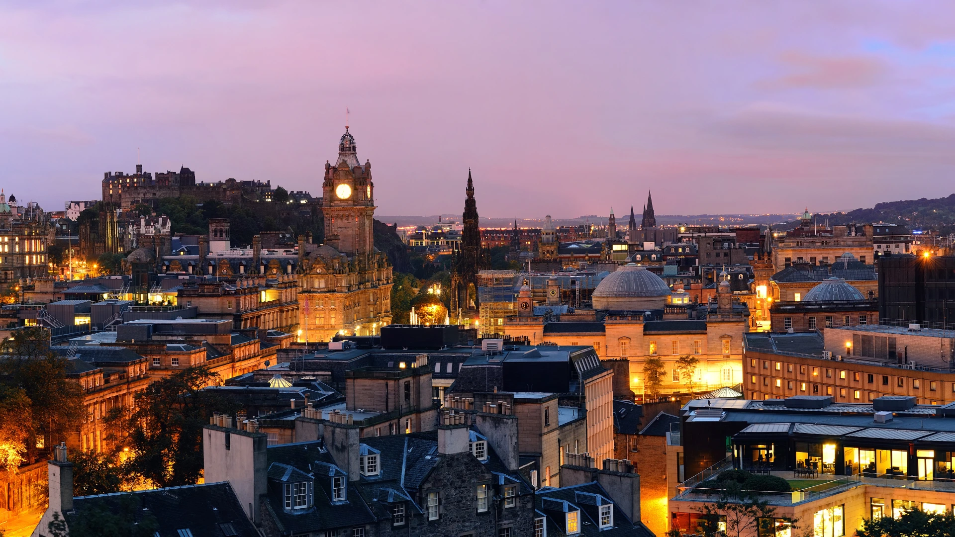 A picturesque view of the Edinburgh skyline lit up with lights. 