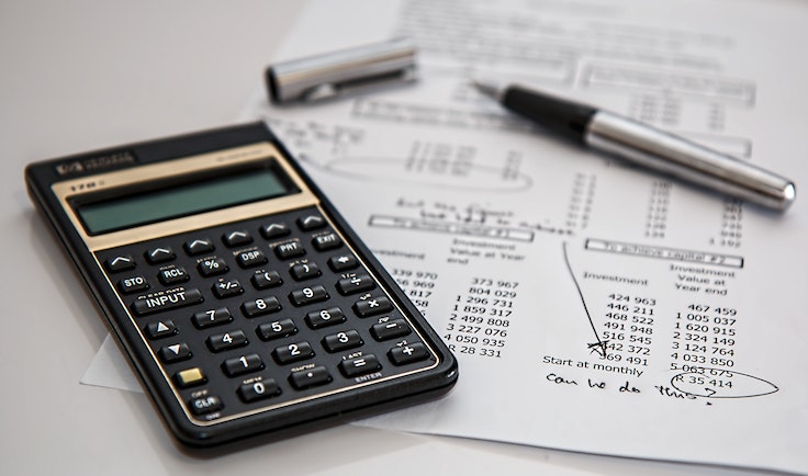 a calculator and pen on a paper