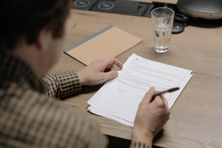 a person writing on a piece of paper
