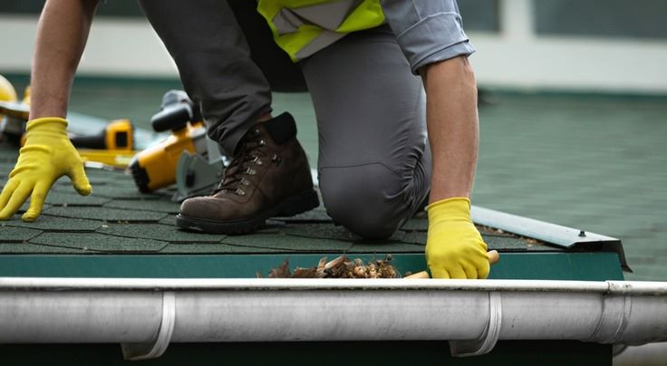 a person cleaning a gutter