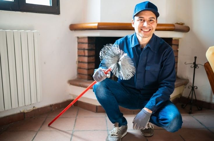 a person squatting down holding a broom