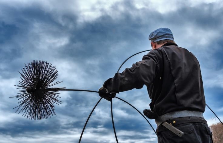 a guy hold a chimney sweeping brush