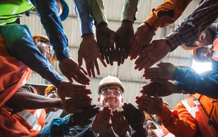 a group of people in a circle with their hands together
