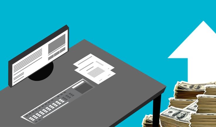 a computer on a desk with a stack of money
