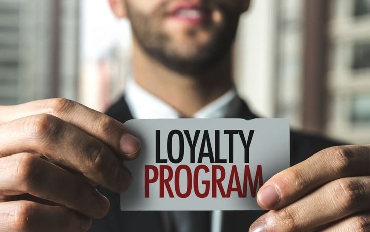 a man holding a loyalty program card