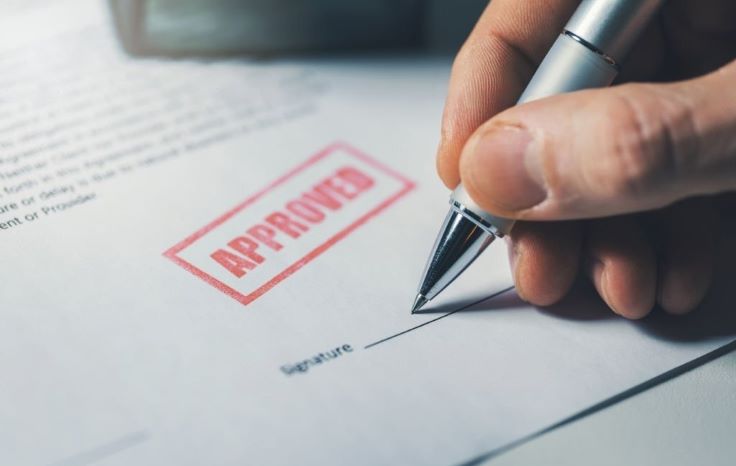 a guy signing a paper