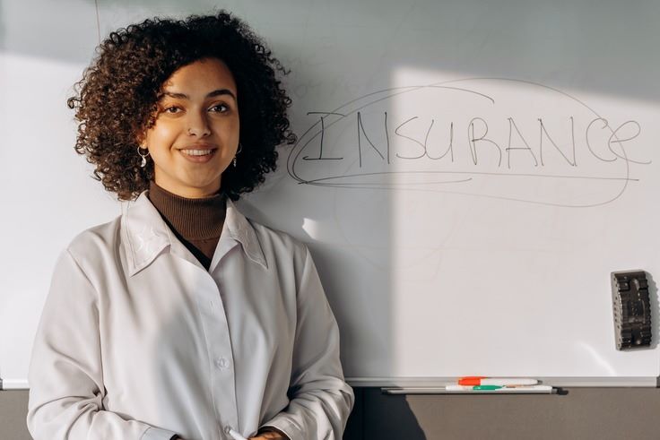 a woman standing next to a whiteboard