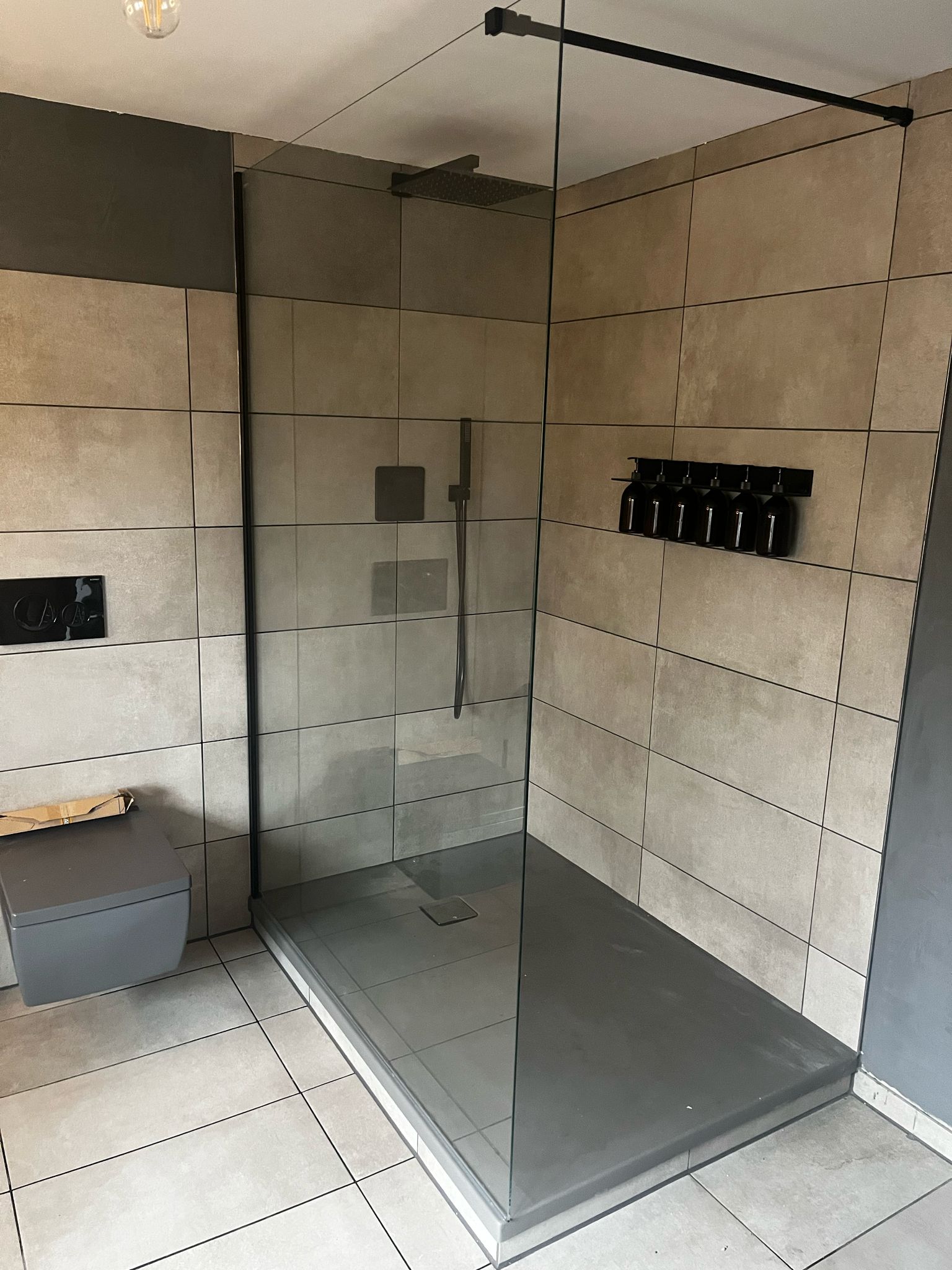 Modernes Badezimmer mit neuer Dusche, Waschbecken und Fliesen