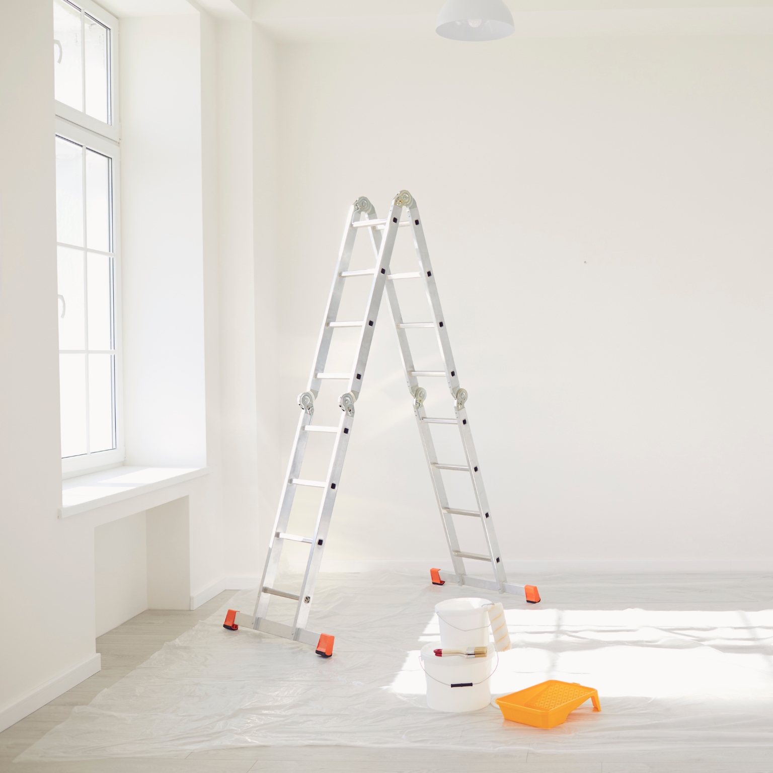 Streichen einer weißen Wand in einem hellen Raum