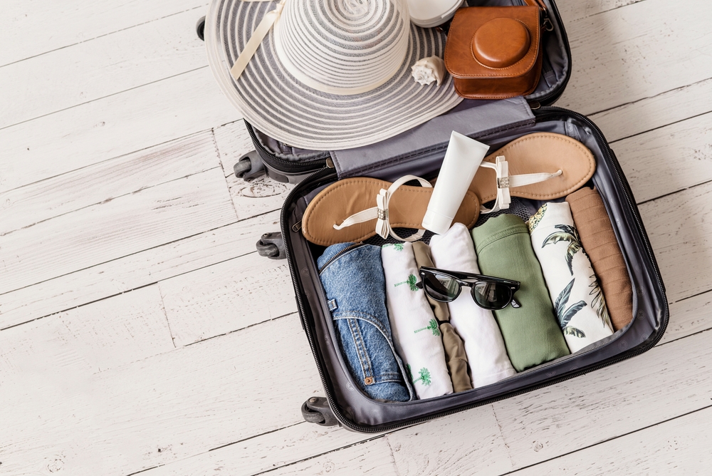 Packing checklist flat lay with passport, clothes, and toiletries Packing checklist flat lay with passport, clothes, and toiletries
