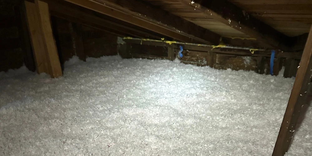 Loose-fill attic insulation installed between rafters to reduce air leakage and improve indoor comfort.