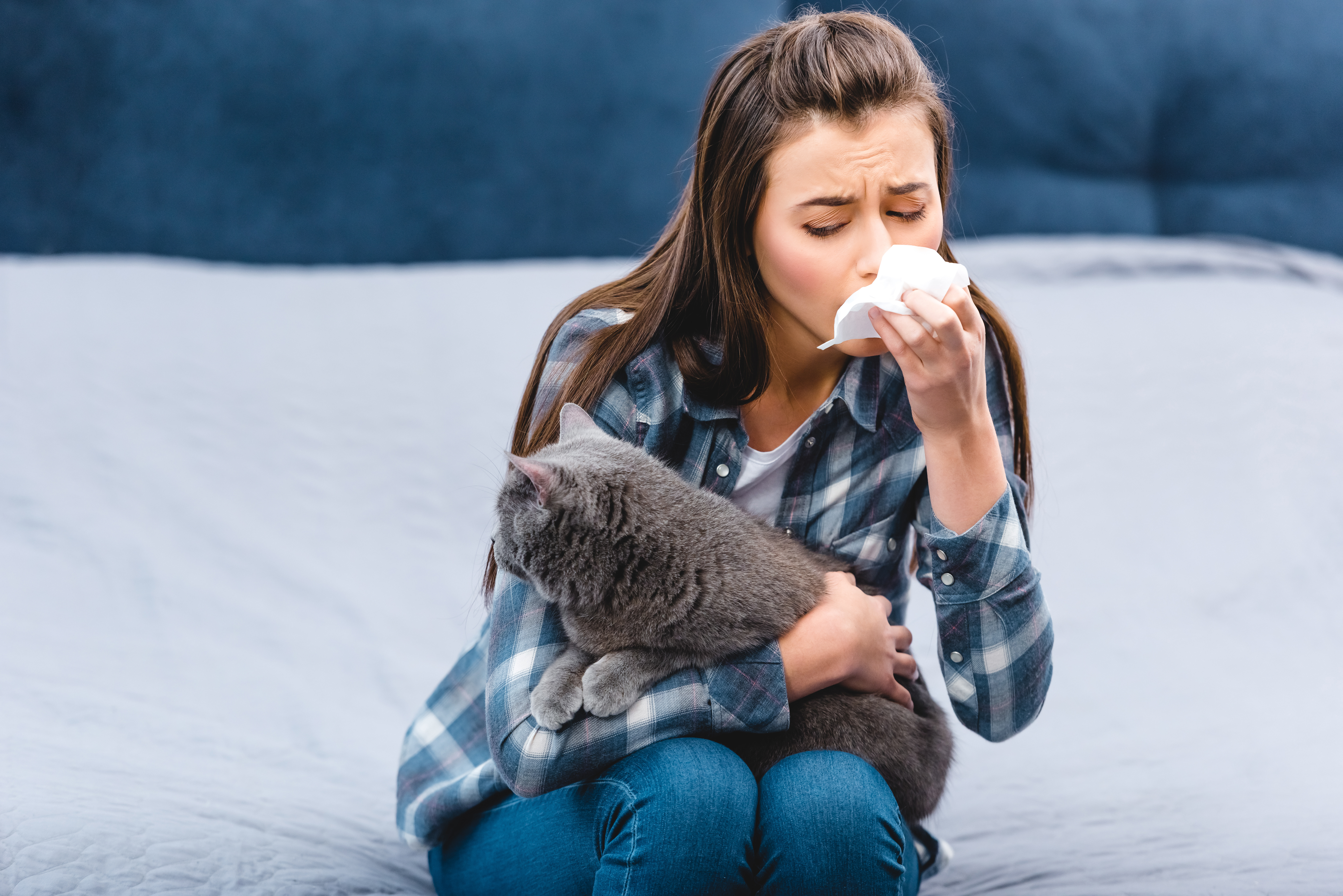 Woman sneezing with cat