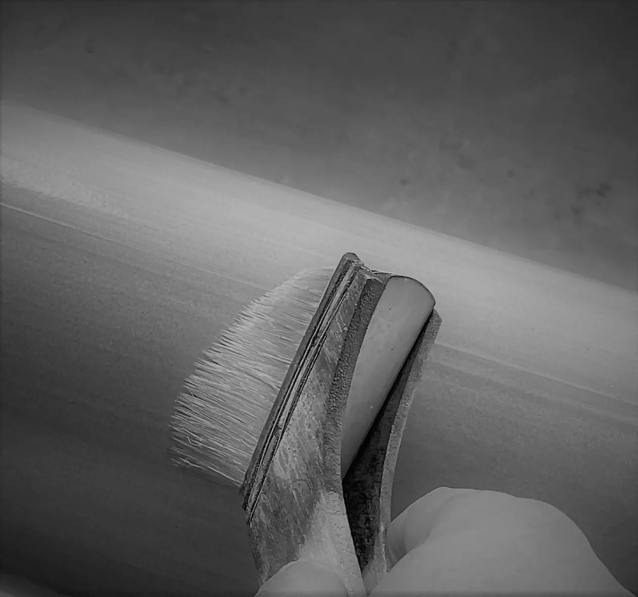 職人が刷毛を手に、スピーカーの表面を一台ずつ仕上げている手元