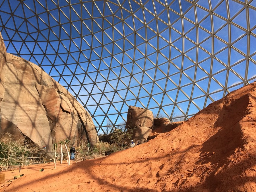 Red desert rocks under a glass geodesic dome