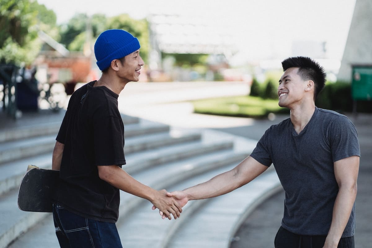 Young men shaking hands as a way to show conflict management