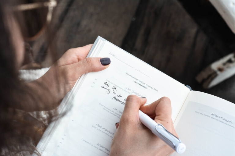 Person writing in a gratitude journal