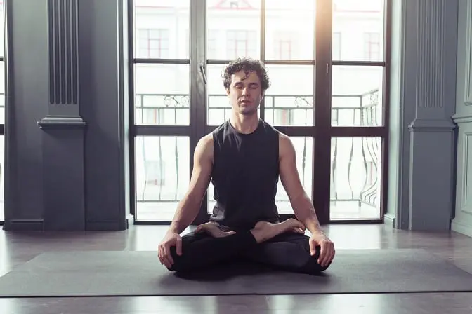 Man meditating on a yoga mat