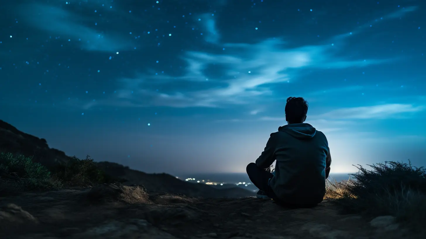 A man sits on a hilltop at night gazes at a star-filled sky, embracing solitude and reflection under the peaceful glow of the cosmos.