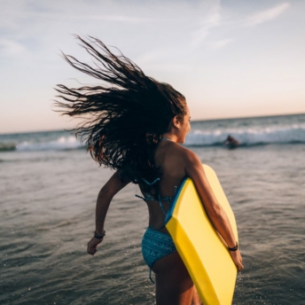 Cute teen girl with a bodyboard at the beach