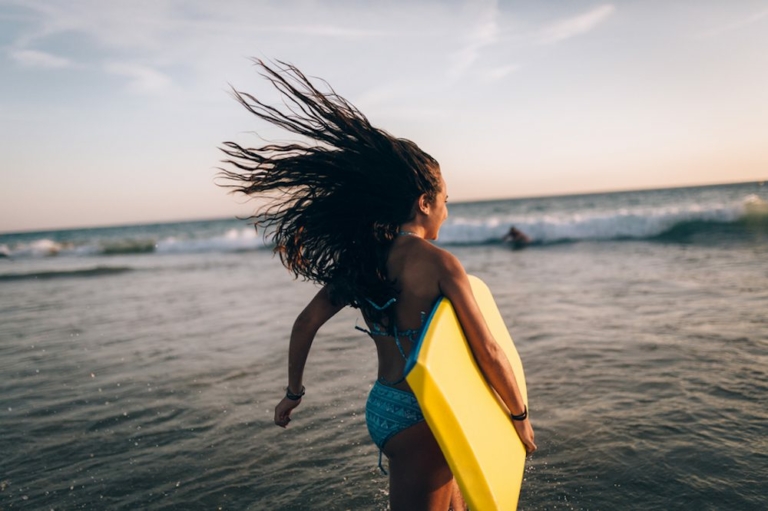 Cute teen girl with a bodyboard at the beach