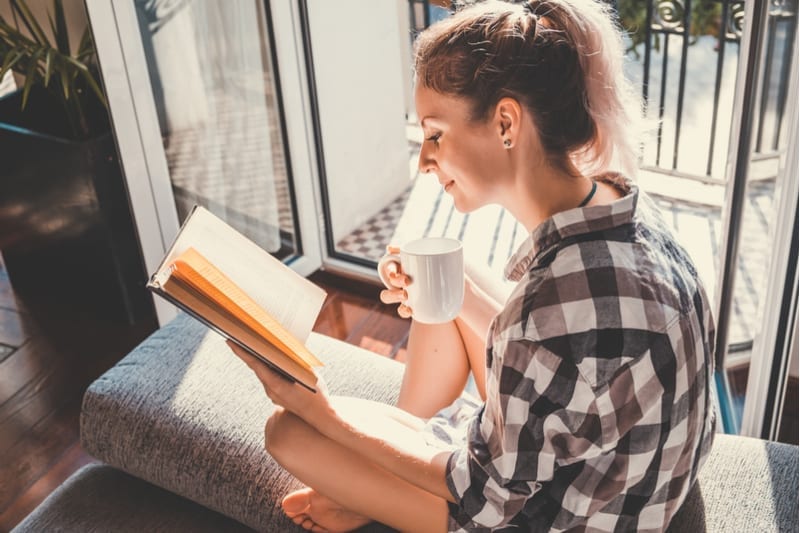 Woman reading next to the window