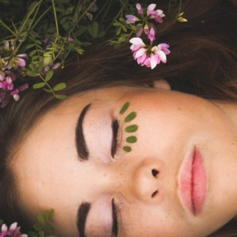 Woman lying in grass and flowers