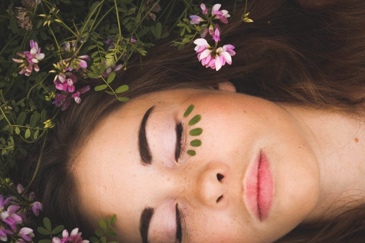 Woman lying in grass and flowers