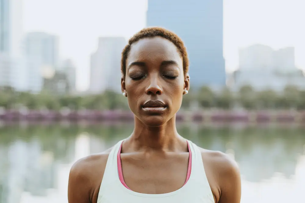 Black lady visualizing in a meditation at a park