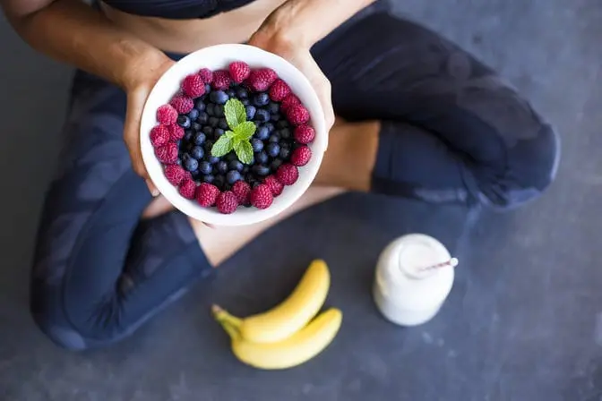 Woman holding a bowl of berries for the Dr. Mark Hyman diet