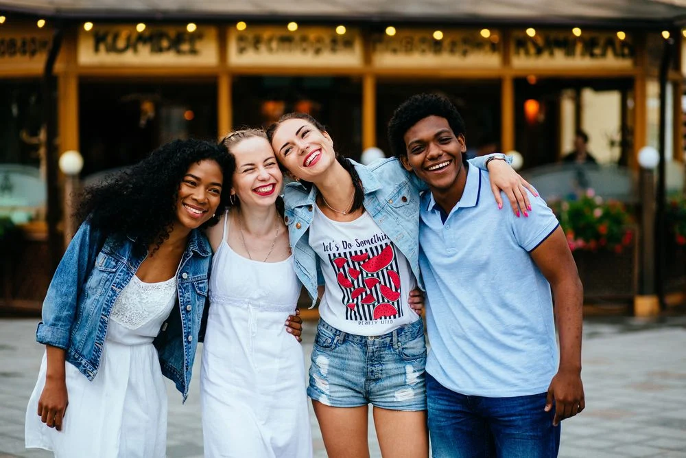 group of smiling young friends laughing and hugging each other group of positive happy people smiling and hugging each other