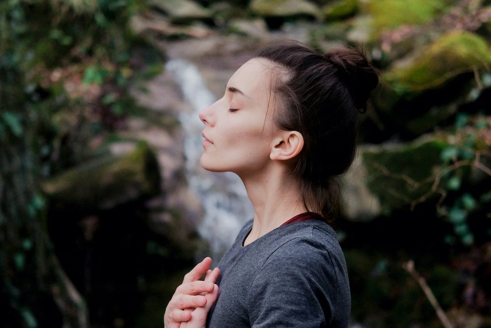 Woman with hands on chest dialing into her intuition