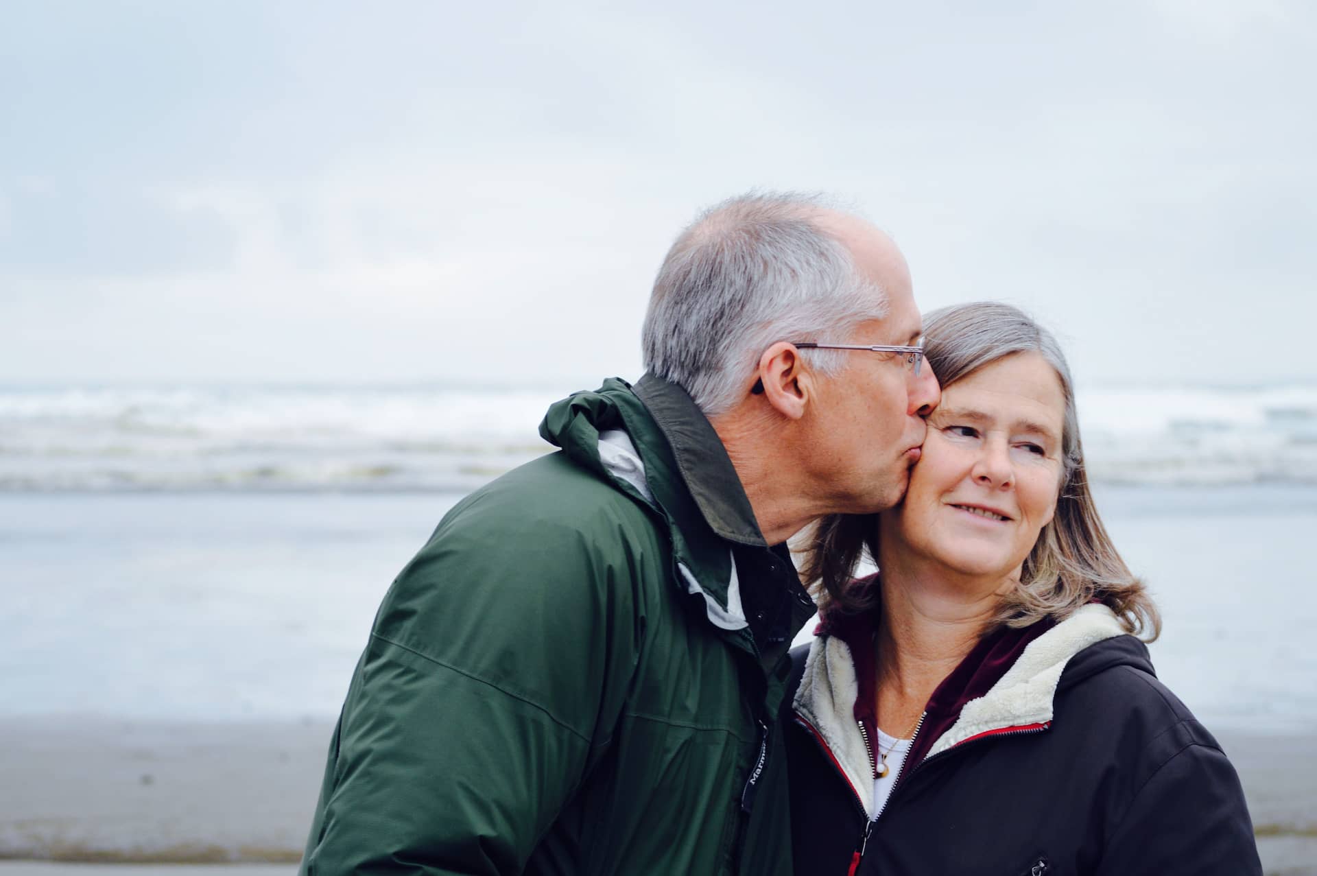 old couple kissing on the beach