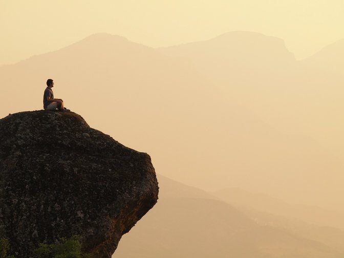 a man sitting on the mountain meditating