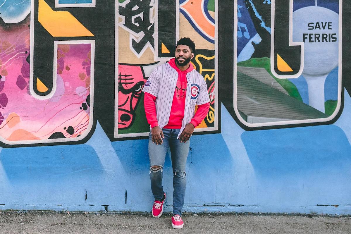 Man in front of a Chicago mural