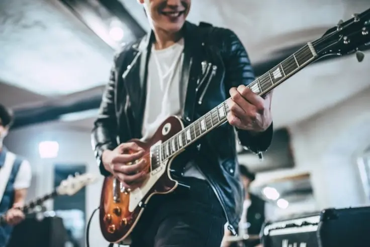 a young man playing electronic guitar