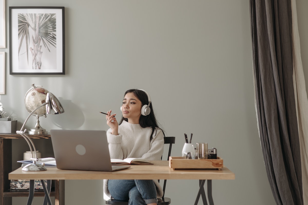 Woman sitting at a desk with a laptop and using analytical intelligence