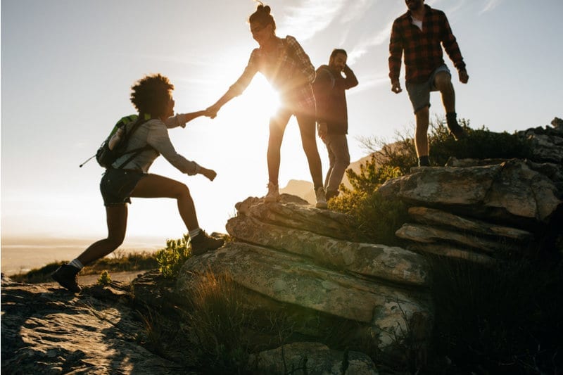 Bodily kinesthetic people helping each other up a hill