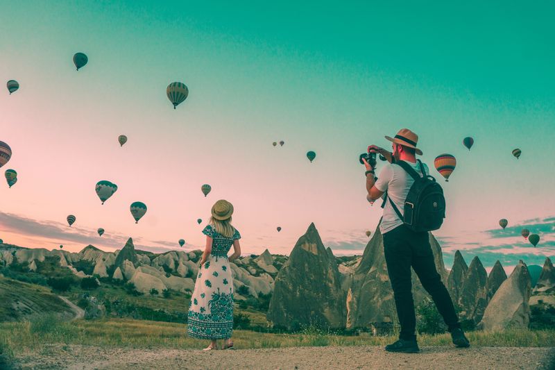 man taking pictures of balloons