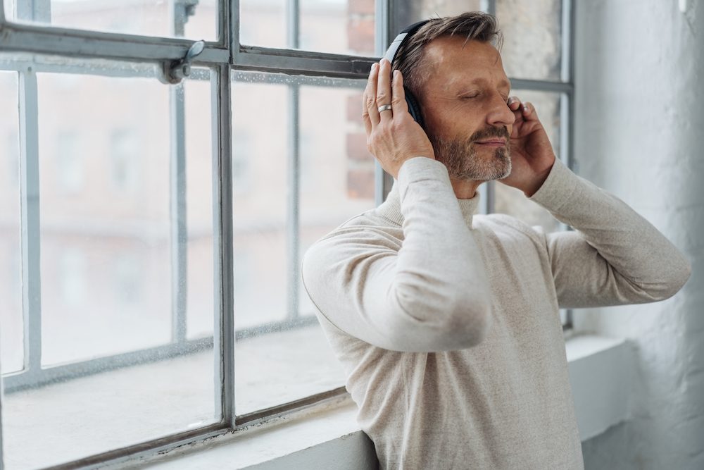 Man focusing on slow breaths and listening to meditation
